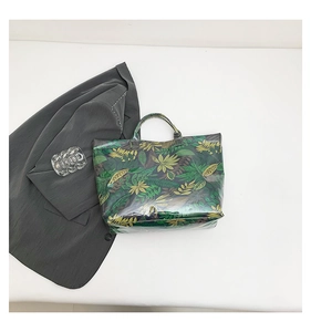 Top view of a large tote bag with green tropical plant print and transparent PVC layer