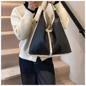 Dettaglio della borsa tote vintage in pelle nera con finiture in ecopelliccia di pecora