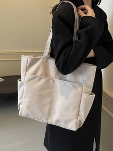 Sac fourre-tout beige minimaliste de grande capacité avec poches porté par mannequin