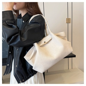 Dettaglio della borsa tote in tela bianco avorio con texture e fibbia in metallo