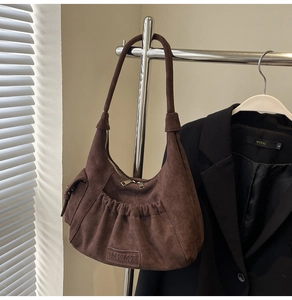 Detailed view of dark brown suede hobo bag with front pleated pocket and dual zipper
