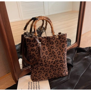 Vista dettagliata della borsa tote leopardata con manico in bambù e tracolla in uno specchio