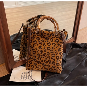 Dettaglio della borsa tote leopardata con manico in bambù e tracolla in pelle