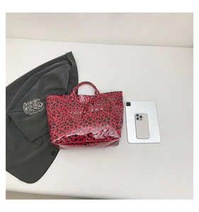 Detail view of red leopard print tote bag capacity with a tablet and phone inside