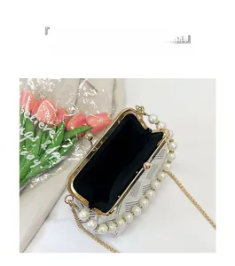 Top-down detail of an open white pearl chain bag with V-pattern and black lining storage