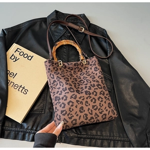 Dettaglio della borsa tote leopardata con manico in bambù e tracolla in pelle marrone
