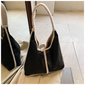Dettaglio della borsa tote in ecopelle nera con bordo in lana sherpa bianca e manici