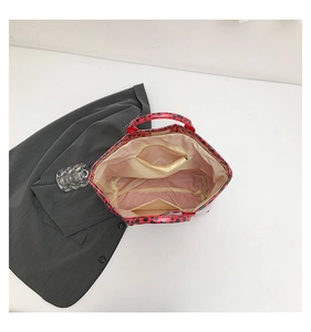 Interior detail of red leopard print tote bag with light lining and zipper pocket