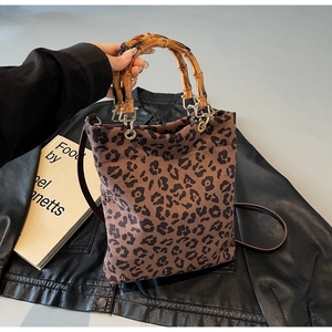 Dettaglio del manico in bambù e della stampa leopardata sulla borsa tote alla moda