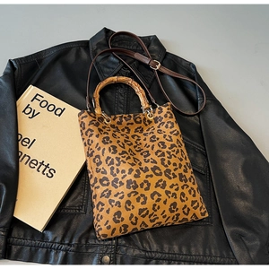 Dettaglio della borsa tote leopardata con manico in bambù e tracolla in pelle marrone