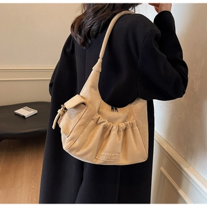 Detail of beige suede hobo bag with pleated texture and side flap pocket for women