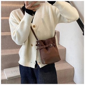 Vue détaillée latérale d'un sac seau vintage marron foncé en daim avec empiècement cuir