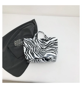 Detail view of glossy zebra print tote bag with reflective synthetic leather finish