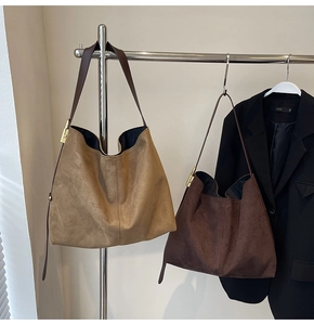 Close-up of minimalist faux suede tote bags in khaki and dark brown with metal buckles