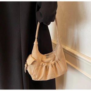 Detail view of khaki suede tote bag with half-moon shape and MKMX leather logo detail