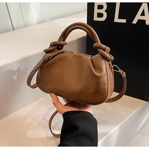 Dettaglio borsa nuvola a pieghe in pelle marrone scuro con manico a nodo e tracolla sottile