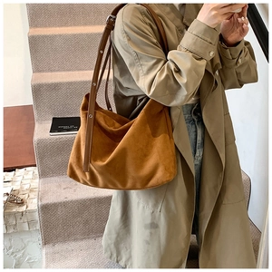 Detailed view of brown matte PU leather tote bag with adjustable strap on a model