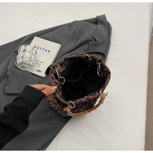 Interno dettagliato della borsa leopardata con manico in bambù e tasca interna con zip