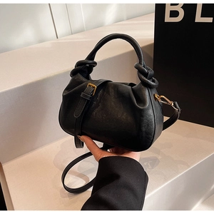 Dettaglio borsa a nuvola nera con manico a nodo e ganci metallici dorati eleganti