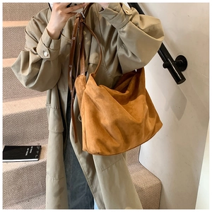 Close-up of brown suede hobo bag with adjustable leather strap and matte texture