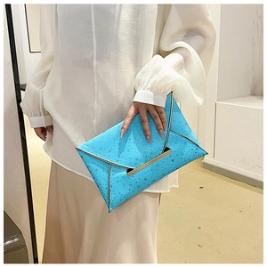 Gros plan de la pochette enveloppe bleu vif avec motifs d'étoiles et bords métalliques