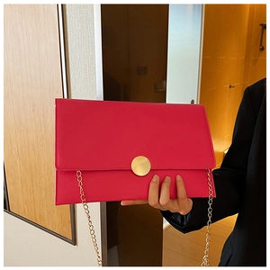Dettaglio della pochette fucsia a busta con fibbia magnetica dorata e tracolla