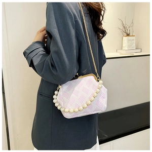 Chic women's pearl handle frame bag with pink geometric pattern worn with blue blazer