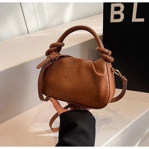 Dettaglio borsa a nuvola marrone a pieghe con texture morbida e logo di moda