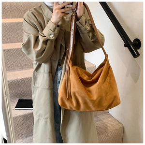 Close-up of caramel suede tote bag featuring adjustable shoulder strap and matte finish