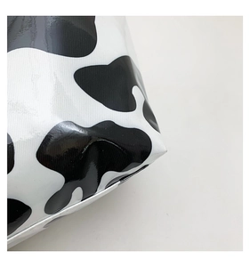 Detailed close-up of cow print glossy tote bag with high-shine waterproof material and stitching