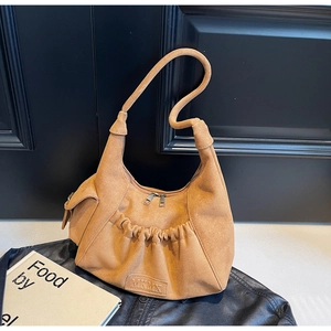 Close-up of caramel suede hobo bag featuring pleated layers and MKMX brand leather label