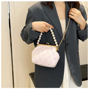 Detail of retro frame bag with pink geometric pattern and oversized pearl handle