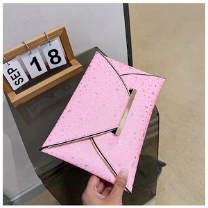 Vue détaillée d'une pochette enveloppe rose ornée de paillettes étoiles et bordure dorée