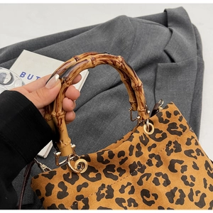 Dettaglio borsa tote leopardata con manico in bambù e anelli in metallo dorato lucido