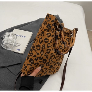Dettaglio ravvicinato della borsa leopardata con manico in bambù e tracolla in pelle