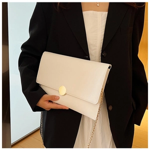 Dettaglio di una borsa a busta in pelle bianca con fibbia dorata su una modella