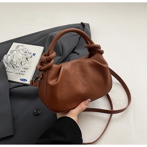 Dettaglio di una borsa a nuvola marrone pieghettata con manico a nodo e logo inciso