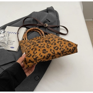 Dettaglio borsa leopardata con manico in bambù e tracolla in pelle sintetica regolabile