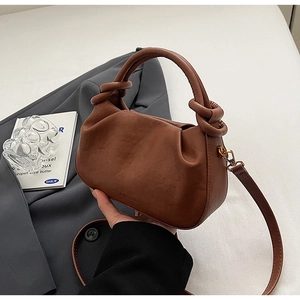 Dettaglio di una borsa a nuvola marrone con pieghe, manico a nodo e logo impresso