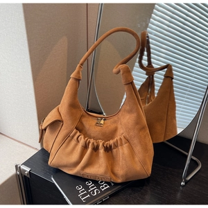 Detail view of brown suede hobo bag with pleated texture and dual metal zippers