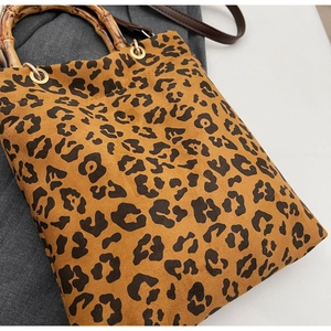 Dettaglio della borsa leopardata vintage con manico in bambù naturale e anelli dorati