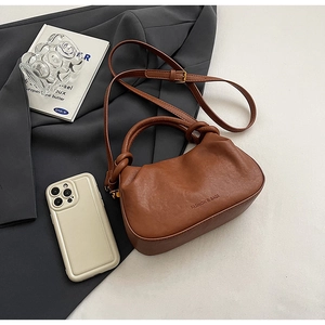 Dettaglio della borsa a nuvola plissettata in pelle marrone con manico a nodo e logo