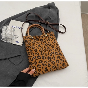 Dettaglio borsa shopper leopardata con manico in bambù e finiture in metallo dorato