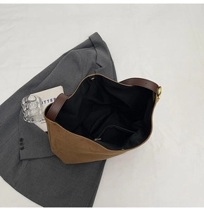 Macro view of spacious brown suede tote bag with leather straps and interior pocket