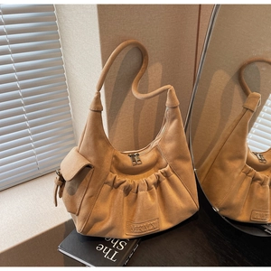 Detail of camel suede tote bag featuring pleated front and small side flap pocket