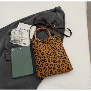 Dettaglio borsa tote leopardata con manici vintage in bambù e tracolla in pelle marrone