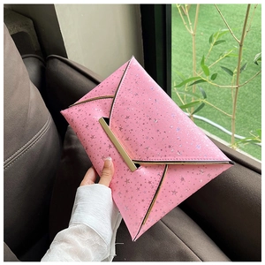 Détail de la pochette enveloppe rose avec motifs d'étoiles et fermoir doré en métal