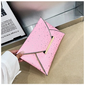 Détail de pochette enveloppe rose avec étoiles argentées et garniture dorée en V