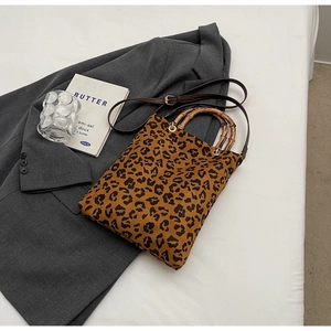 Dettaglio borsa tote leopardata con manici in bambù naturale e tracolla regolabile