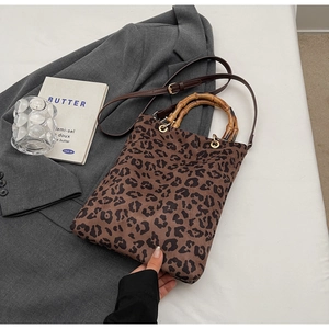 Dettaglio della borsa tote leopardata con manici in bambù vintage e tracolla in pelle